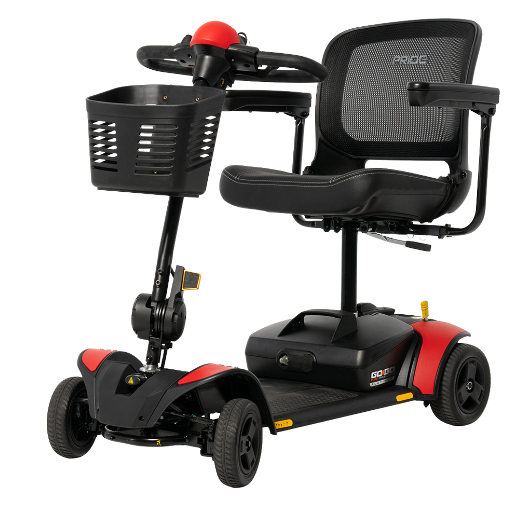 The Pride Mobility Go Go Elite Traveller® 2 Platinum Scooter is a compact travel scooter with a black mesh seat, armrests, steering handlebar, front basket, and red accents on the wheel covers and base.